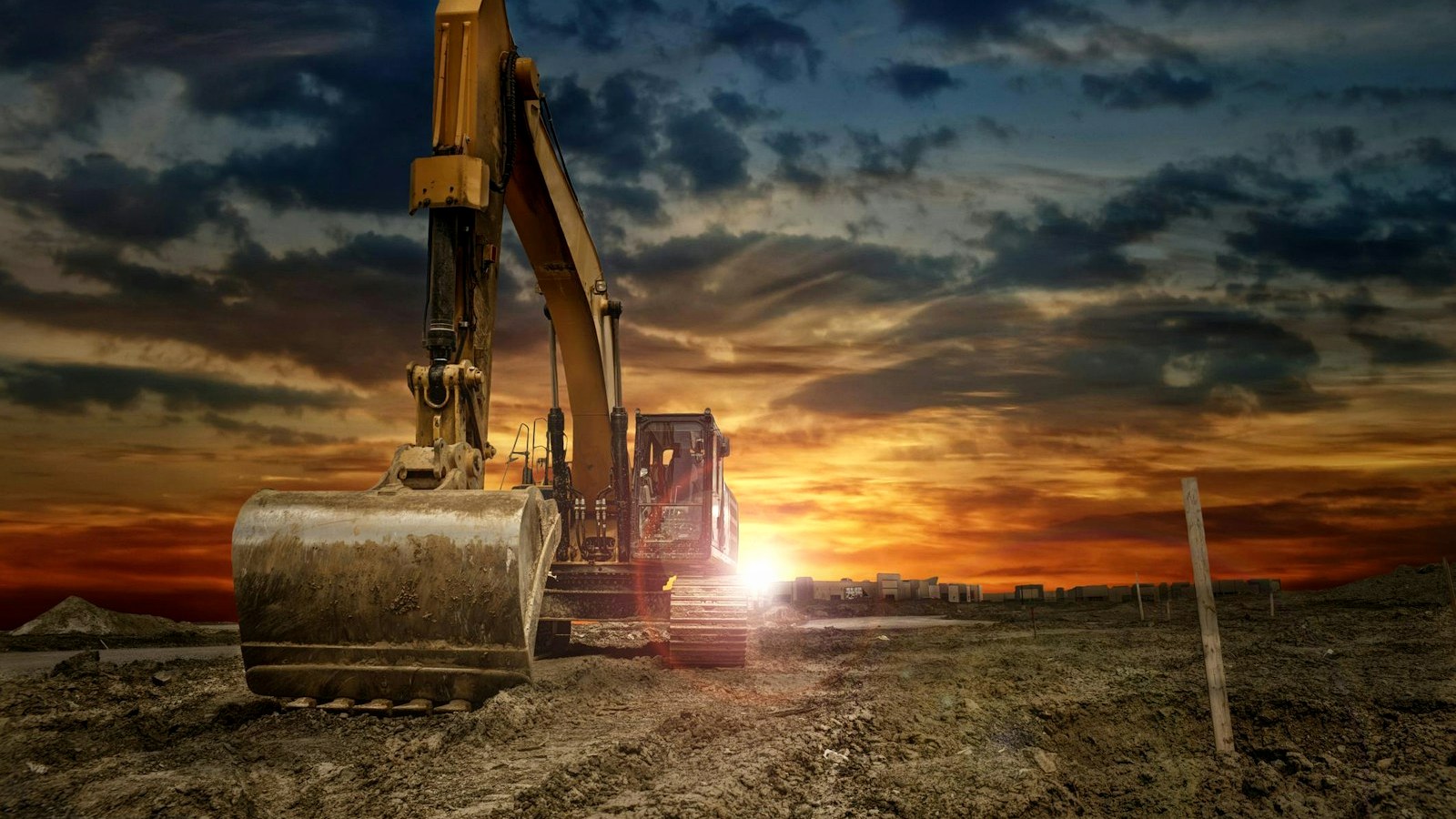 Excavator working at a construction site at sunset