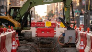 Electric excavator on an urban utility trench jobsite